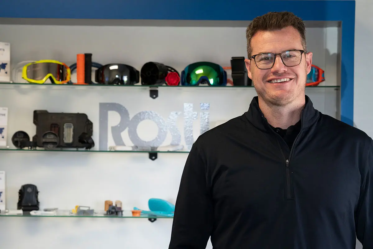 A Male staff in front of products that been Injection molded at Rosti Utah