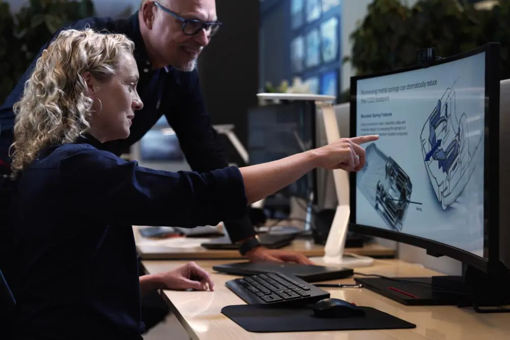 Two engineers, one pointing at a screen with a innovation/Design.