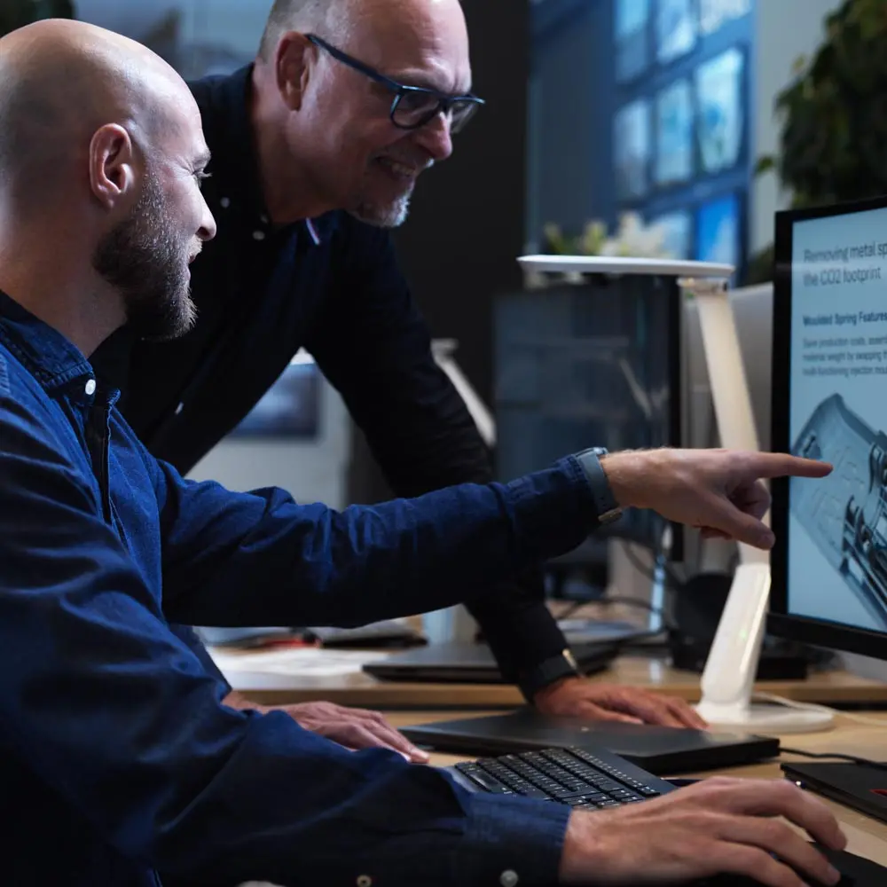 two men are discussing something on a computor screen.