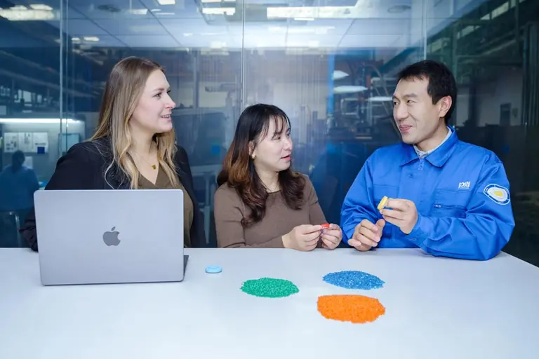 three staff talking about material