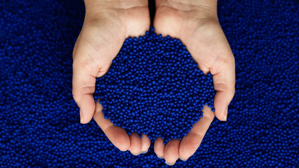 Two hands holding blue plastic resin for Plastic injection mouldig.