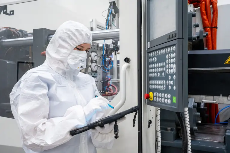 medical production staff looking at machine