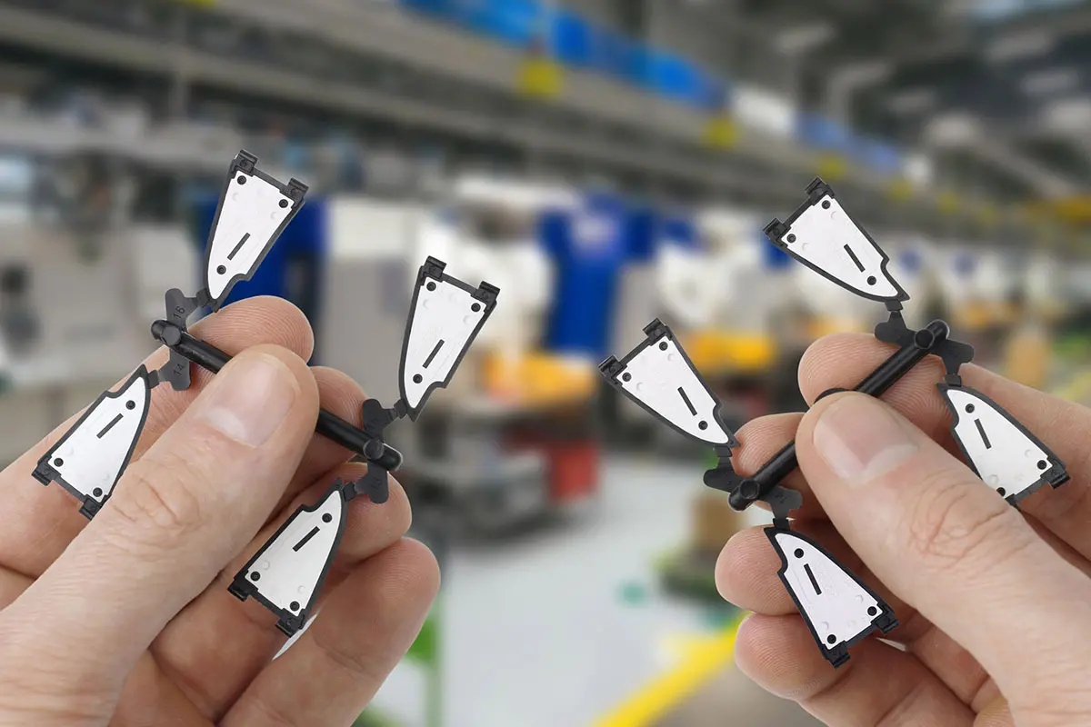 two hands holding small pieces of perfectly molded Multi-shots 2K