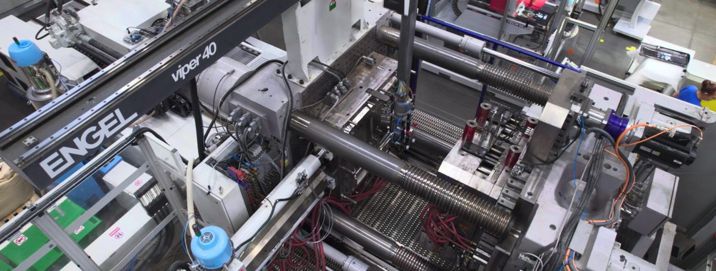 A teal colored part being moulded