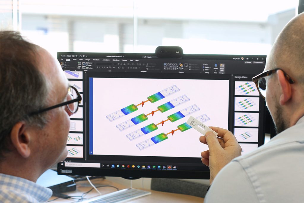 two Rosti staff in front of computor and simulation
