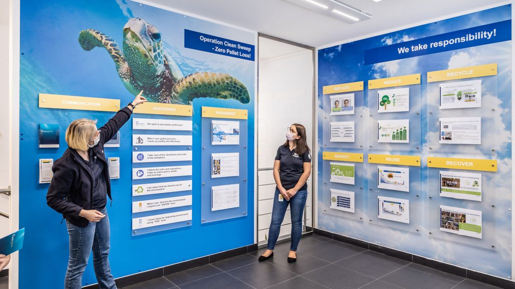 Two members of Rosti Staff, one bpointing at a turtle