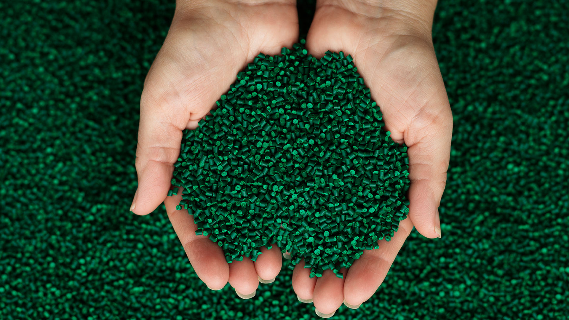 Rosti Green Resin Pellets in Hands